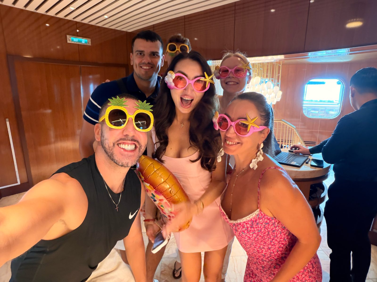 Friends taking a selfie with fun sunglasses onboard