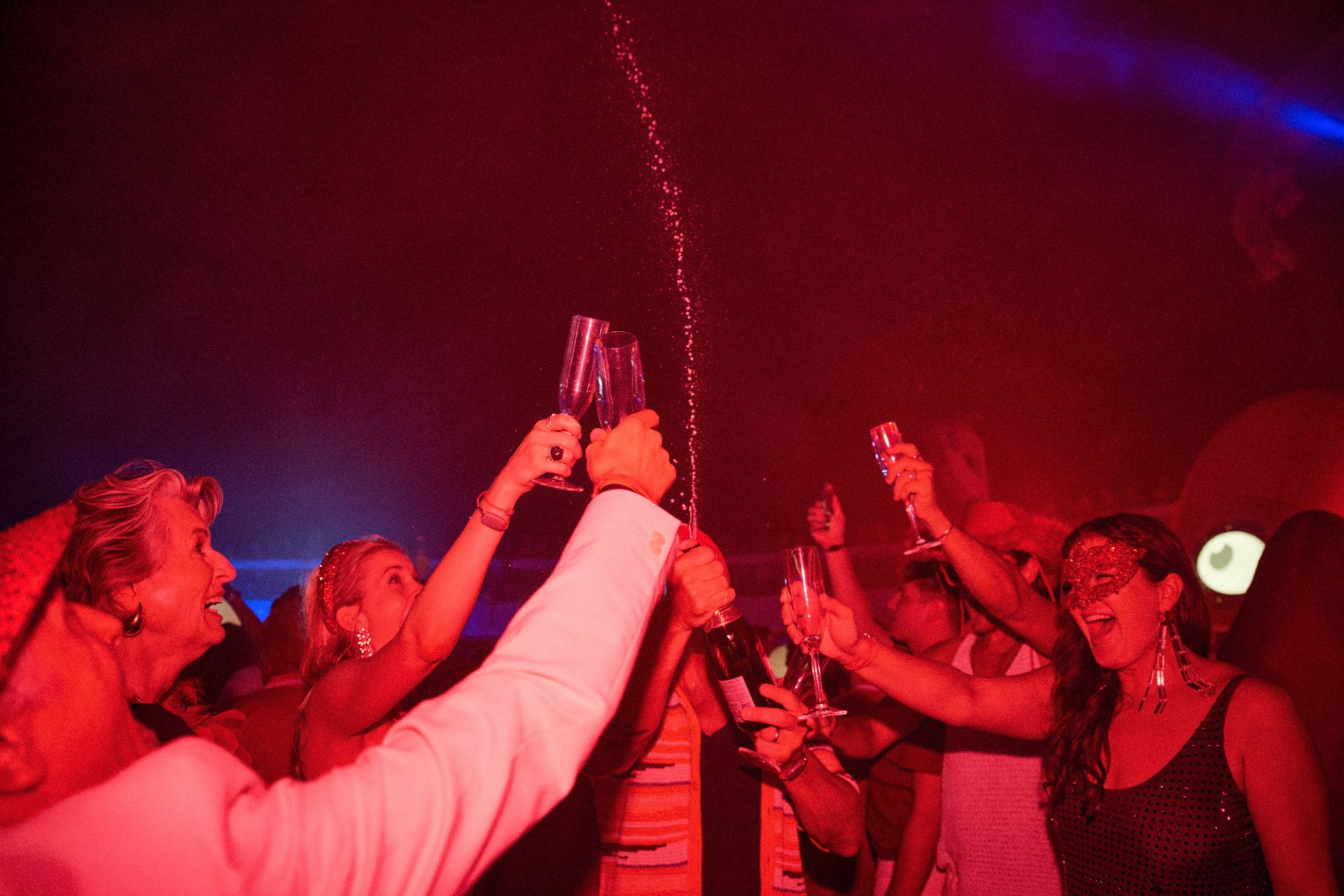Friends celebrating with champagne at a Scarlet Night party