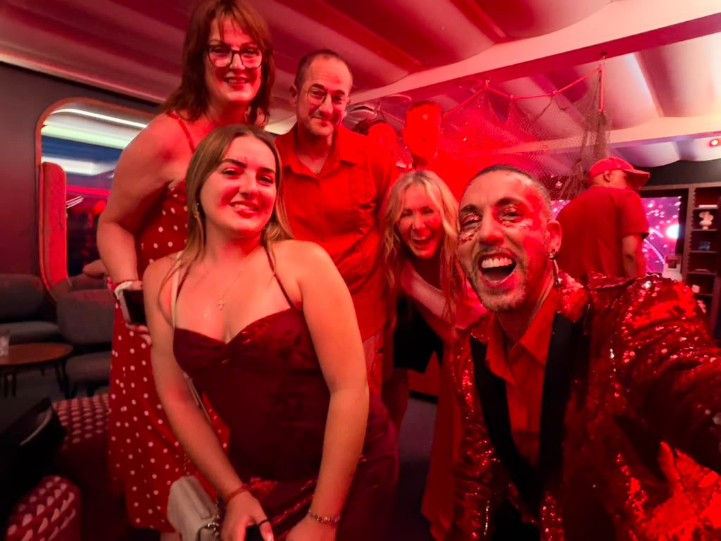 Group of travelers posing together at a red-themed party